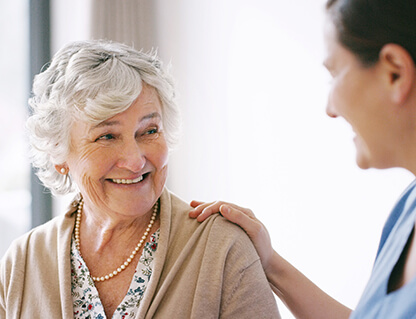 Senior woman smiling at her nurse