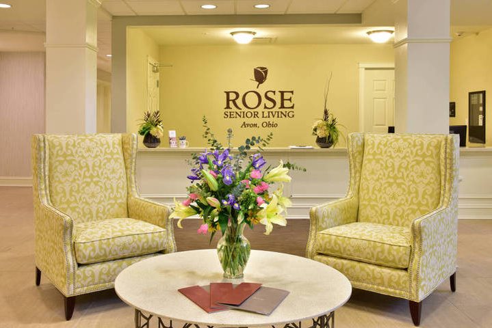 Elegant lobby at Rose Senior Living with armchairs and floral centerpiece in Avon, Ohio.