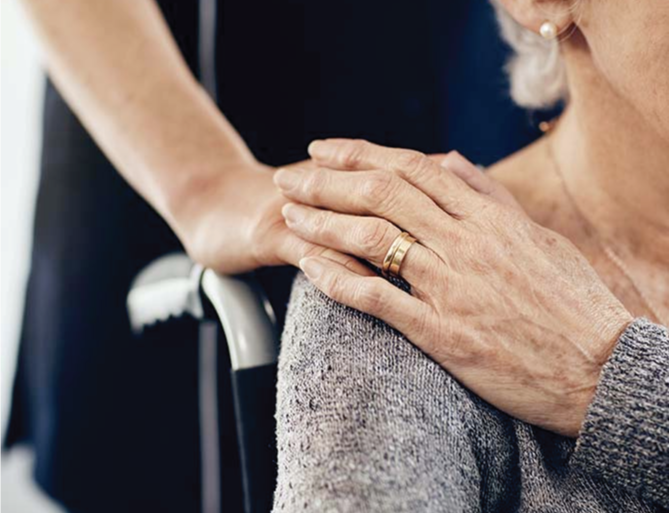 Staff placing their hand on the shoulder of a resident