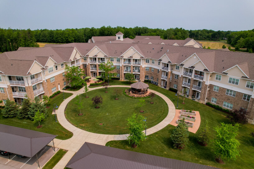 Aerial view of a large residential complex with a central courtyard, landscaping, and walkways.