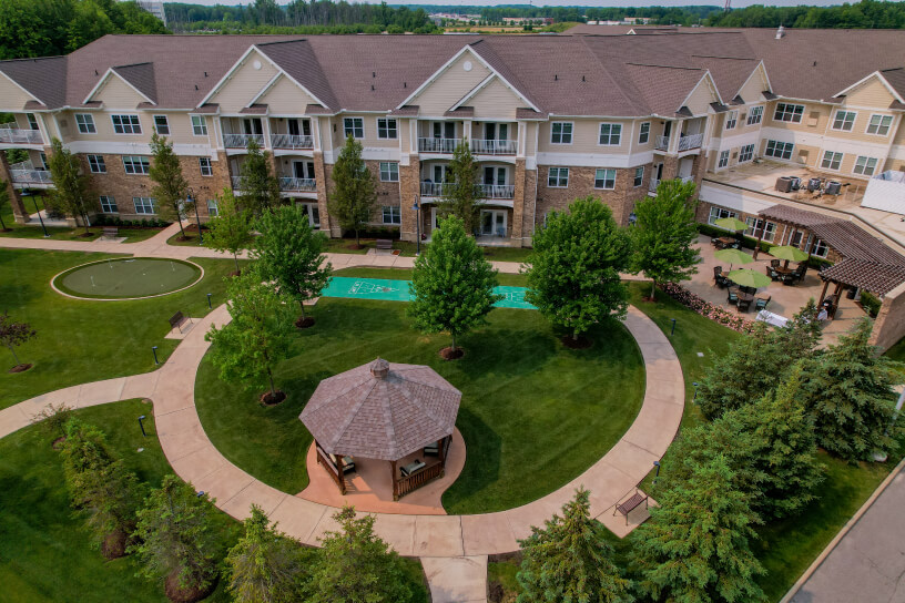 Senior living facility with a landscaped courtyard, gazebo, pool, and surrounding walkways