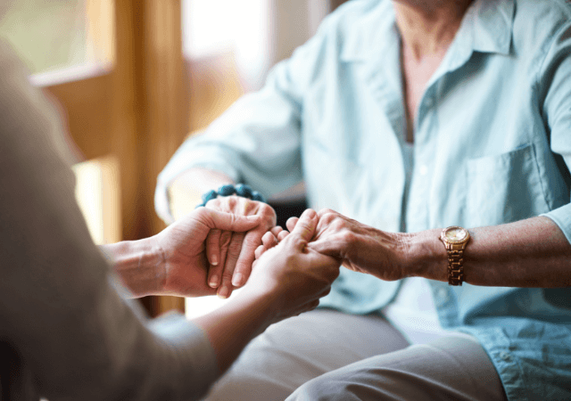 Senior woman holding the hands of a staff member