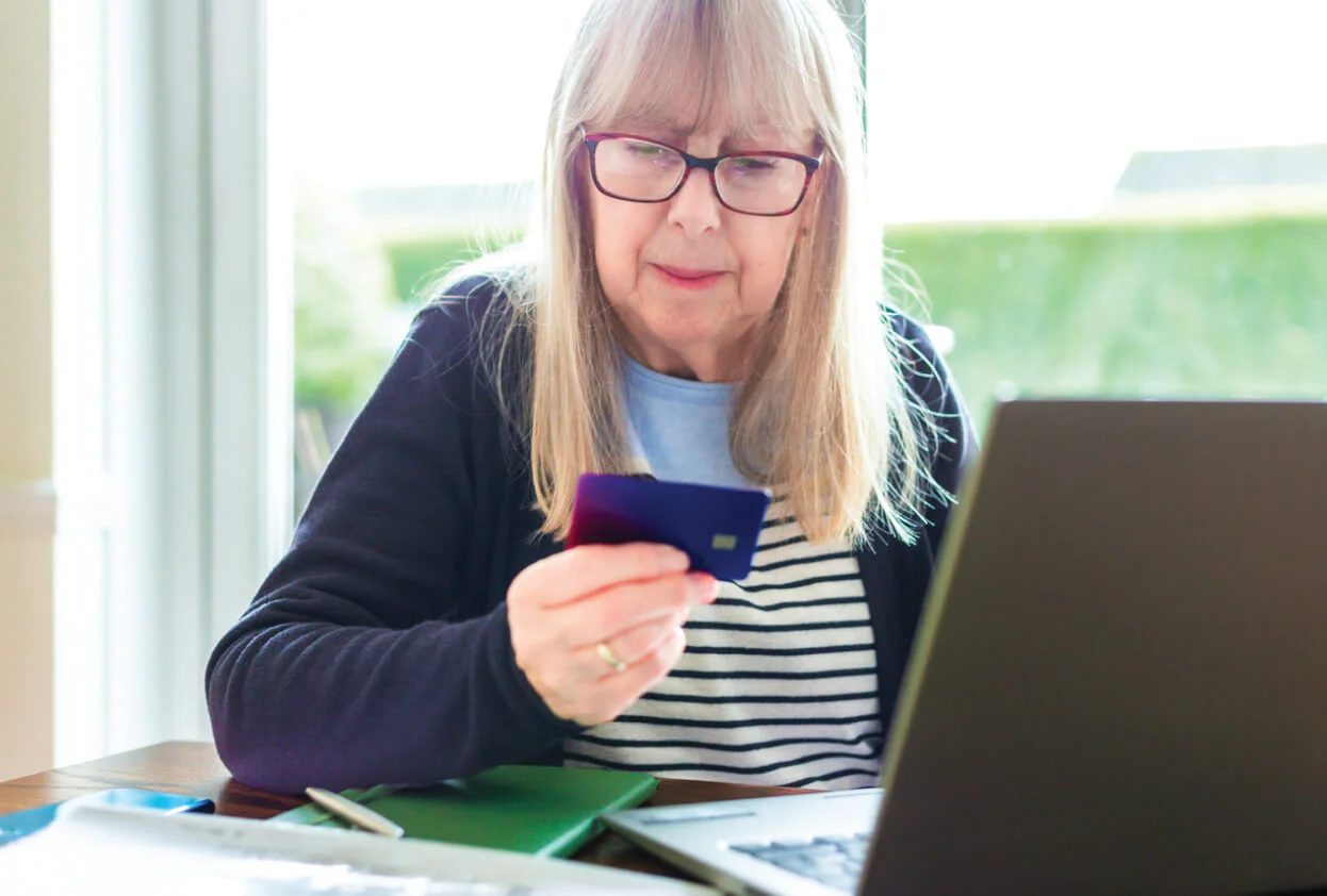 Senior woman looking at credit card